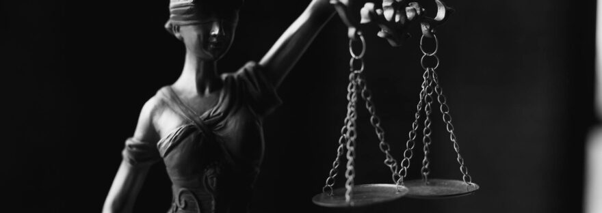 a grayscale of a lady justice figurine